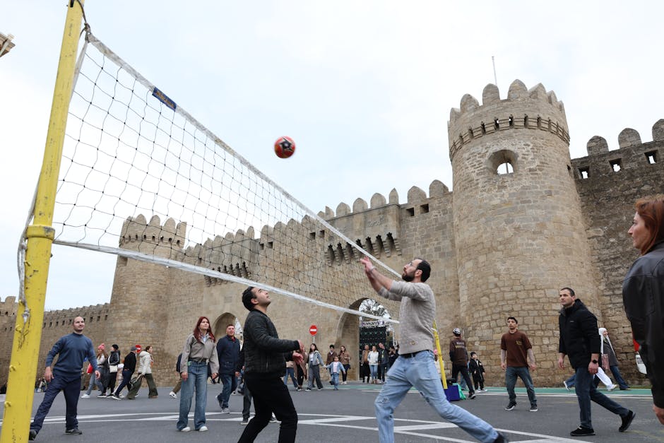 Antik bir kale duvarının yakınında voleybol oynayan bir grup, spor ve tarihin iç içe geçtiği bir anı yakalıyor.