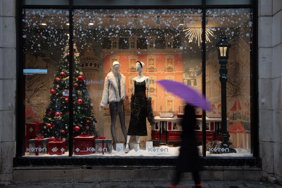 İstanbul'da, mankenler ve şenlikli bir ağaçla süslenmiş, Noel temalı ürünlerin sergilendiği, muhteşem bir şekilde dekore edilmiş bir mağaza vitrini.