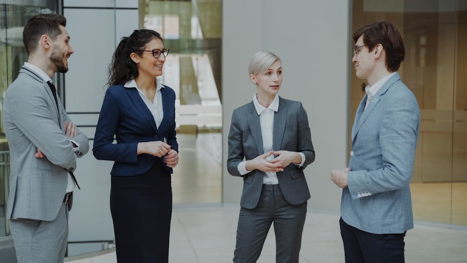 Modern bir ofis ortamında sohbet eden, farklı iş dünyasından profesyonellerden oluşan bir grup.